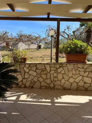 a stone wall with two potted plants and a street light at Baglio Cracchiolo da Tuzzo - Casa Bouganville in San Vito lo Capo