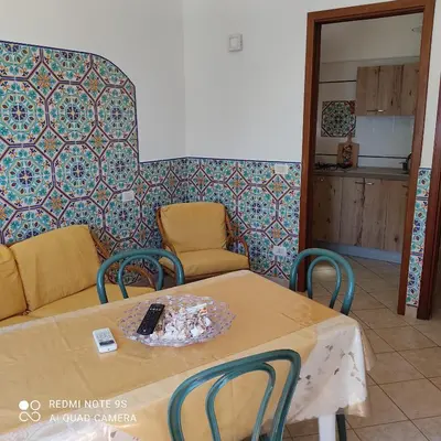 a room with a table with a remote control on it at Baglio Cracchiolo da Tuzzo - Casa Bouganville in San Vito lo Capo