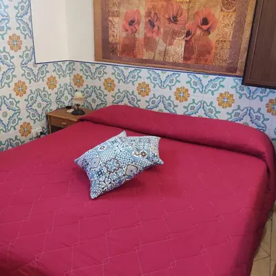 a red bed with a pillow on top of it at Casa Fico D'India in San Vito lo Capo