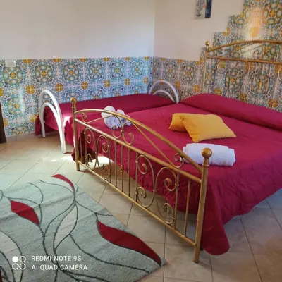 a bedroom with a bed with a red bedspread at Casa Fico D'India in San Vito lo Capo