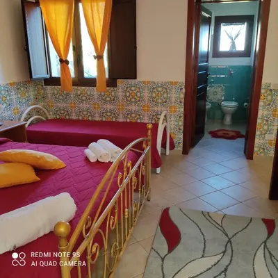 a bedroom with a bed and a bathroom with a tub at Casa Fico D'India in San Vito lo Capo