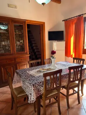 a dining room table with chairs and a vase on it at Baglio Cracchiolo da Tuzzo - Casa Carrubbo in San Vito lo Capo