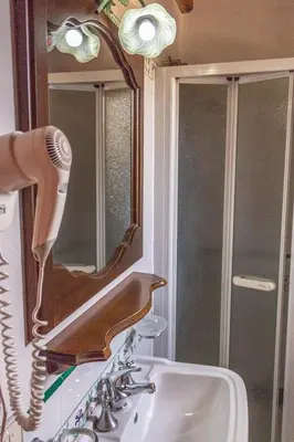 a bathroom sink with a hairdryer on a mirror at Baglio Cracchiolo da Tuzzo - Casa Carrubbo in San Vito lo Capo