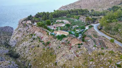 an aerial view of a house on a hill next to the water at Baglio Cracchiolo da Tuzzo - Casa Carrubbo in San Vito lo Capo