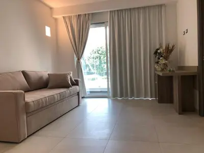 a living room with a couch and a large window at Hotel Pontemare in Palermo