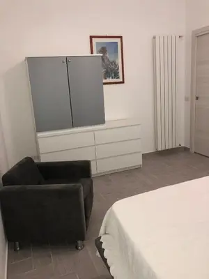 a bedroom with a bed and a chair and a large screen at Casa Tatiana in Palermo
