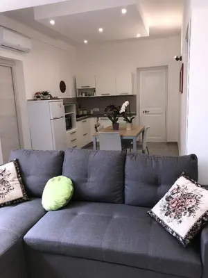 a living room with a blue couch and a kitchen at Casa Tatiana in Palermo