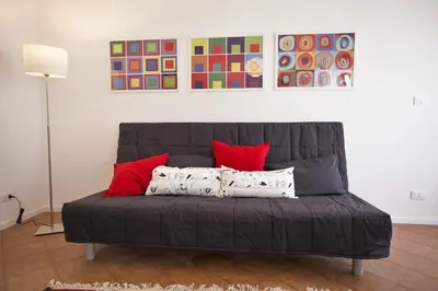 a gray couch with red pillows in a room at GIULIA E CHIARA LUXURY APARTMENT in Castellammare del Golfo