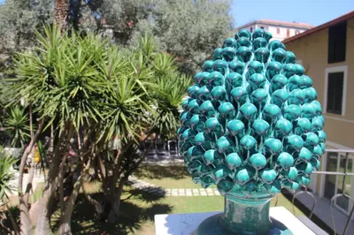 a glass vase filled with green balls on a table at Corte del Merlo in Palermo