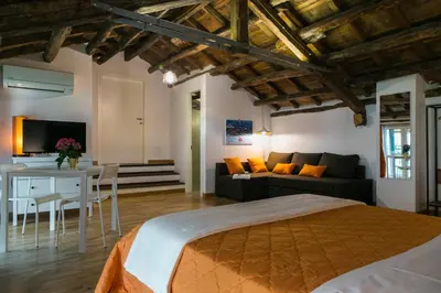 a bedroom with a bed and a living room at Corte del Merlo in Palermo