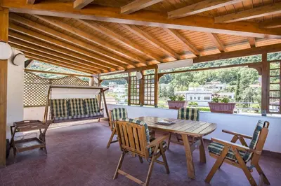 a dining room with a table and chairs on a balcony at Casa con Terrazza sul Mare all'Addaura by Wonderful Italy in Palermo