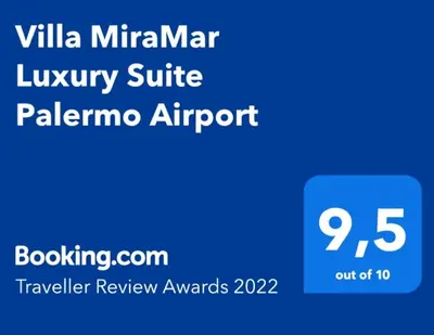 a bottle of wine and two glasses on a table at Villa MiraMar Luxury Suite Palermo Airport in Carini