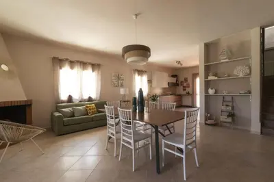 a dining room and living room with a table and chairs at SICULI HORTIS SEA HOME - Villa - Jacuzzi - Air Conditioning - Free Parking - Video Surveillance & Alarm System in Altavilla Milicia