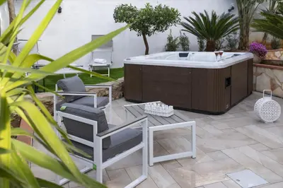 a jacuzzi tub in a yard with two chairs and a table at SICULI HORTIS SEA HOME - Villa - Jacuzzi - Air Conditioning - Free Parking - Video Surveillance & Alarm System in Altavilla Milicia