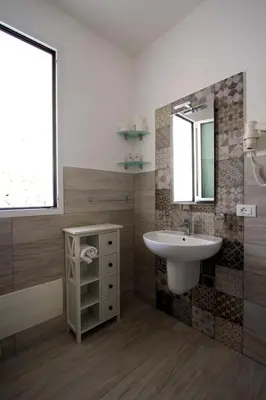 a bathroom with a sink and a mirror at Villa Vitruvio - Giardino degli Allori Scopello in Castellammare del Golfo