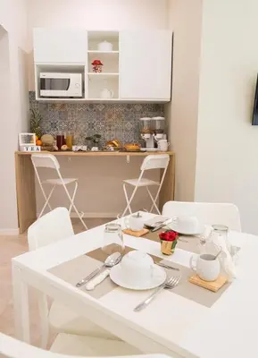a white table with white chairs in a kitchen at Le Stanze Dell'Emiro in Palermo