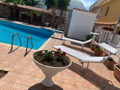 a patio with a flower pot next to a pool at Casa vacanze Villa Grace in Villagrazia