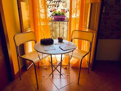 a table with two chairs and a cake on it at Teatro Massimo Apartment- SELF CHECK-IN in Palermo