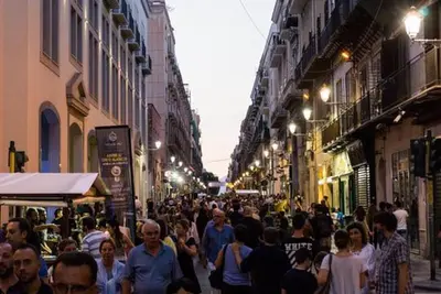 a crowd of people walking down a city street at night at Teatro Massimo Apartment- SELF CHECK-IN in Palermo