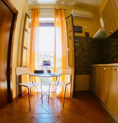 a table and chairs in a kitchen with a window at Teatro Massimo Apartment- SELF CHECK-IN in Palermo