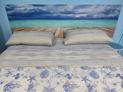 a bed with pillows and a view of the ocean at Aspra al delfino blu in Bagheria