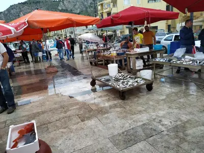 a market with tables with umbrellas in the rain at Aspra al delfino blu in Bagheria