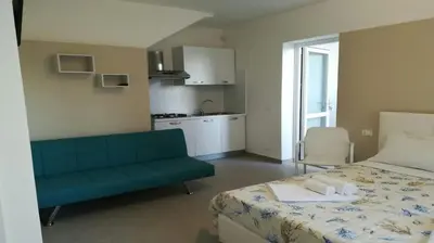 a room with a bed and a couch and a kitchen at Appartamenti centro storico Milazzo Annarita in Castellammare del Golfo