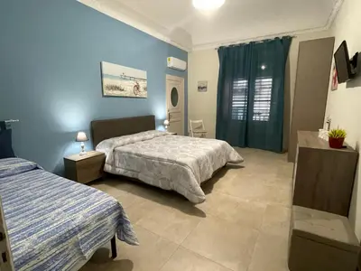 a bedroom with two beds and blue walls at Porte Maqueda in Palermo