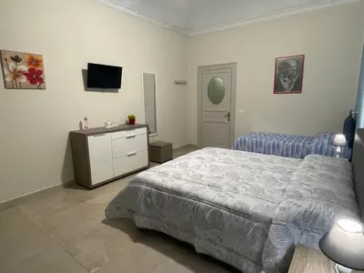 a bedroom with a bed and a dresser and a television at Porte Maqueda in Palermo