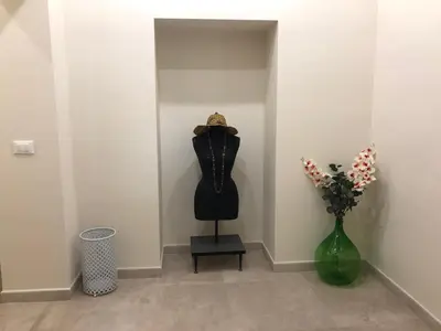a dress on a mannequin in a room with a vase of flowers at Porte Maqueda in Palermo