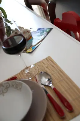 a table with a glass of wine and a spoon at APPARTAMENTO L'AIRONE in Balestrate