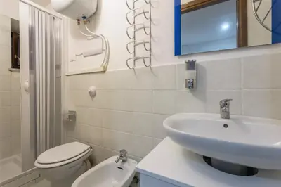 a bathroom with a sink and a toilet and a mirror at La casetta di Sara in Palermo