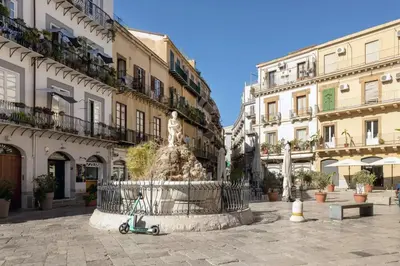 a scooter parked in front of a fountain in a street at La casetta di Sara in Palermo