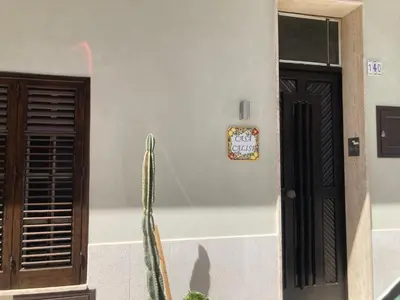 a house with a cactus and a sign on the wall at CASA CALISI in Terrasini