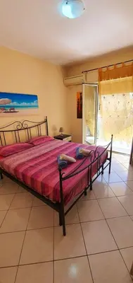 a bedroom with a large bed with a red blanket at Spacious apartment with sea view in Alcamo, 180 m² in Alcamo