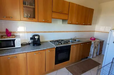 a kitchen with wooden cabinets and a stove and a sink at Spacious apartment with sea view in Alcamo, 180 m² in Alcamo