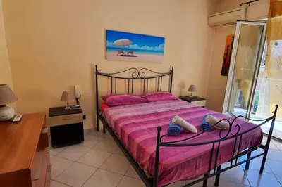 a bedroom with a bed with pink sheets and a desk at Spacious apartment with sea view in Alcamo, 180 m² in Alcamo