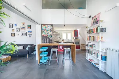 a kitchen and living room with a table and stools at Terrazza dei Colori alla Kalsa by Wonderful Italy in Palermo