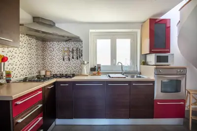 a kitchen with red cabinets and a sink at Terrazza dei Colori alla Kalsa by Wonderful Italy in Palermo