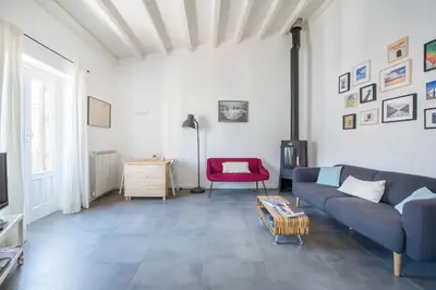 a living room with a couch and a red chair at Terrazza dei Colori alla Kalsa by Wonderful Italy in Palermo