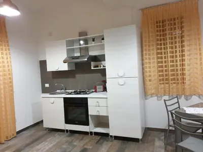 a kitchen with white cabinets and a stove top oven at CASE VACANZE NONNA NICK in Castellammare del Golfo