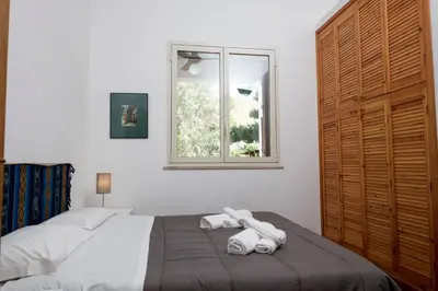 a bedroom with a bed with two towels on it at Villa Gina con vista mozzafiato sul golfo di Macari in Macari