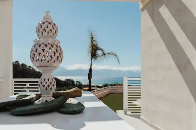 a white vase sitting on a table with some cucumbers at Giardini del Golfo Villa al Mare in Balestrate