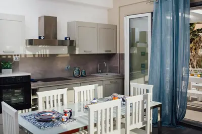 a kitchen with a table and chairs and a kitchen with a sink at Giardini del Golfo Villa al Mare in Balestrate