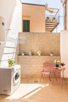 a patio with a washing machine and a red chair at Casa marty in Mondello