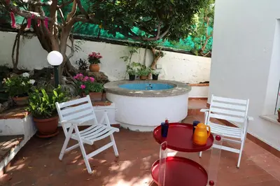 a patio with two chairs and a bath tub at Casa Elvira in Terrasini