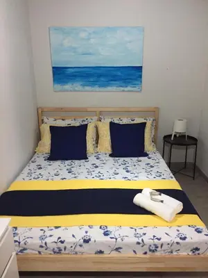 a bedroom with a bed with blue and yellow sheets at Terra e Mare in Capaci