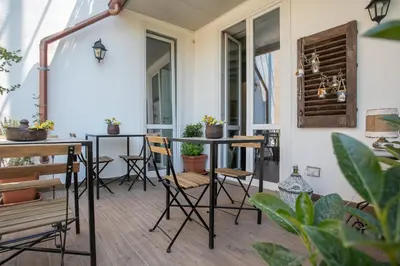 a patio with chairs and a table and some plants at Addimora Boutique Suites in Palermo