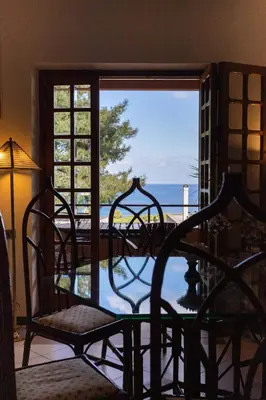 a room with a glass door with a view of the ocean at Villa nel verde sul mare, Mondello, Palermo in Palermo