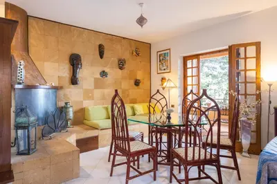 a living room with a table and chairs at Villa nel verde sul mare, Mondello, Palermo in Palermo